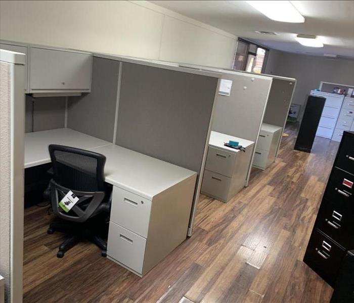 Office space showing cubicles and other furniture on damaged flooring