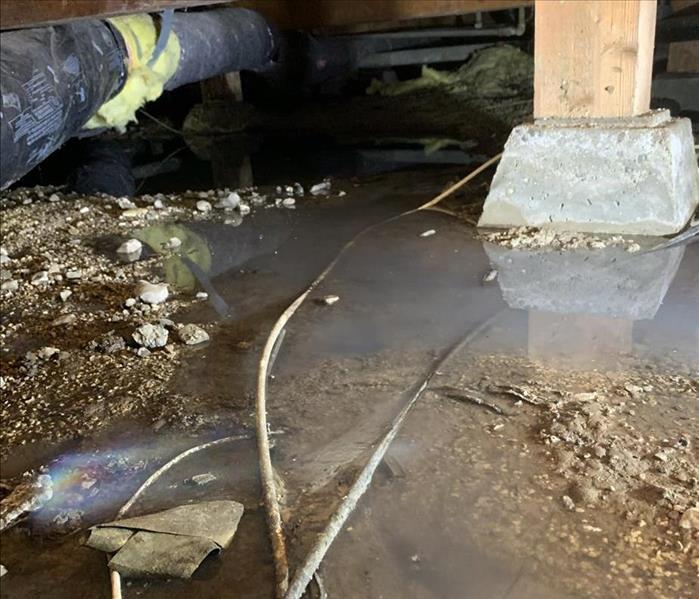 Crawlspace with standing water from a broken pipe