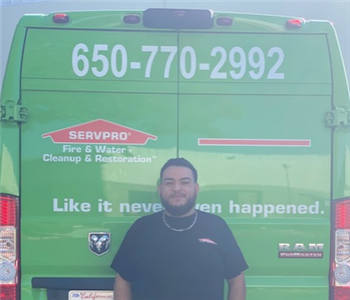 male senior technician in front of green SERVPRO vehicle